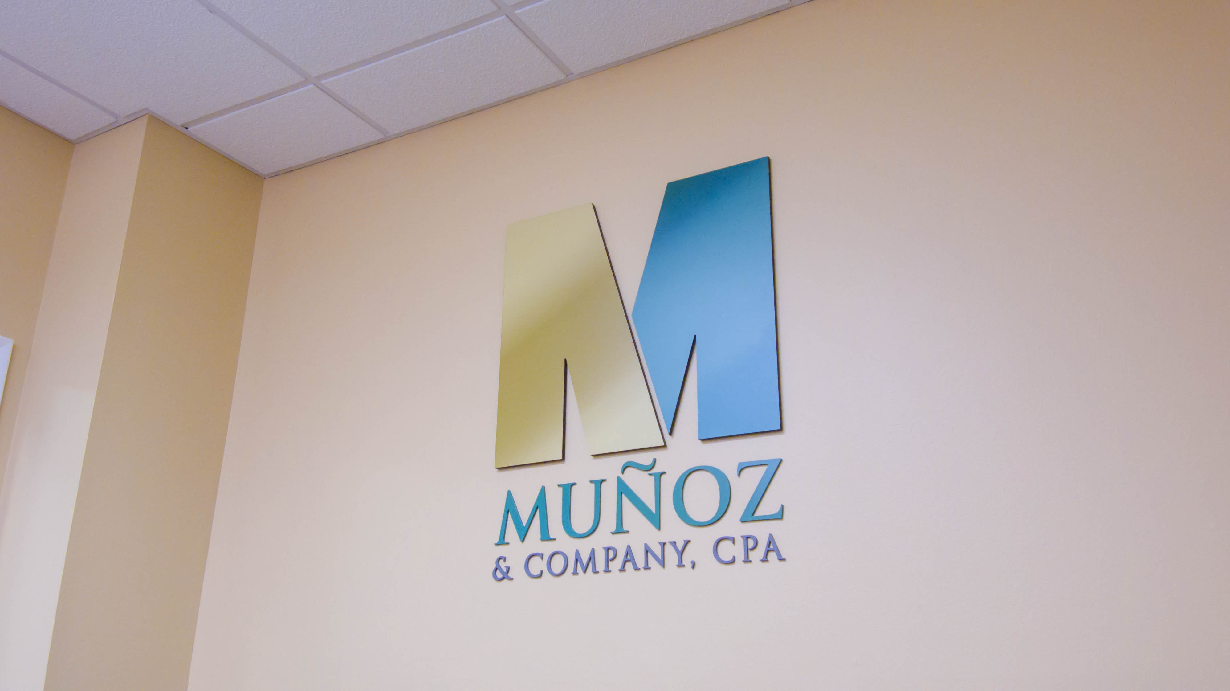 Munoz & Company logo sign on a beige wall